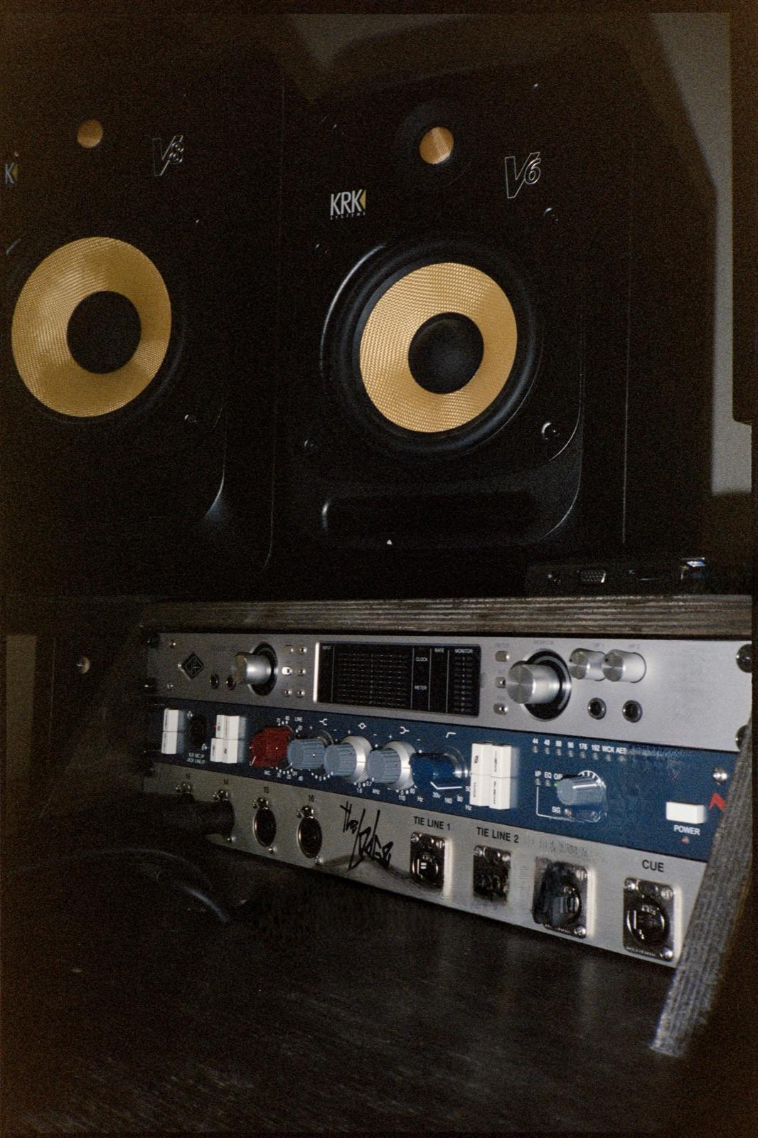 The control room at Recovery Studio, lit low with KRK monitors and outboard gear